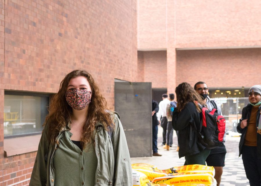 A+UMass+Boston+student+walks+into+McCormack+Hall+wearing+a+mask.