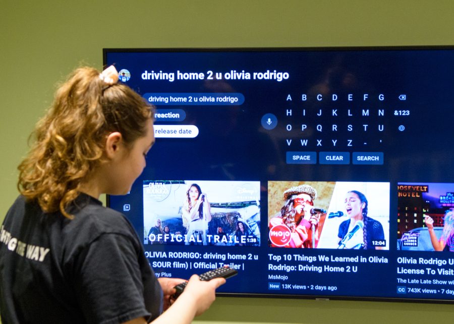 UMass Boston student Riley Hammond watches “driving home 2 u” in the East Residence Hall, March 30 2022.