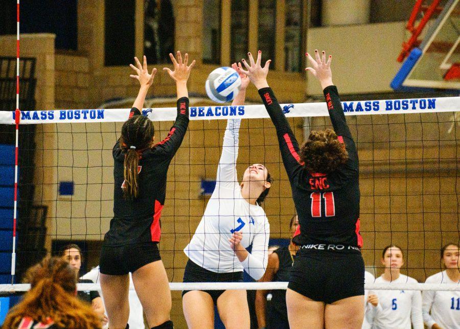UMass Boston’s Livia Trindade (#7) spikes against two opponents in the match against Eastern Nazarene College on Sep. 7, 2022.
