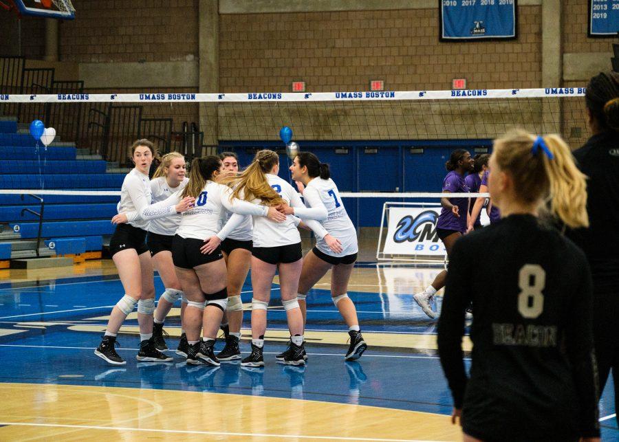 UMass Boston’s womens volleyball team huddles after scoring a point against Emerson College on Oct. 27, 2022.