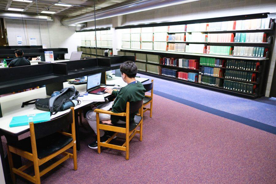 A UMass Boston student works on assignments in the Healey Library.