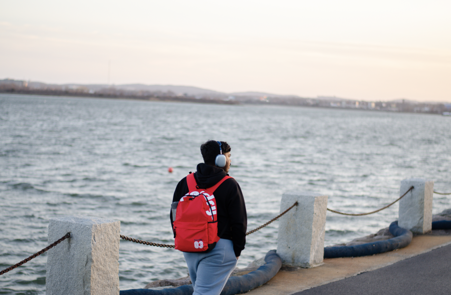 A student takes a stroll by the harbor, to the rhythm of their favorite music. Photo by Saichand Chowdary (He/Him) / Mass Media Contributor.  