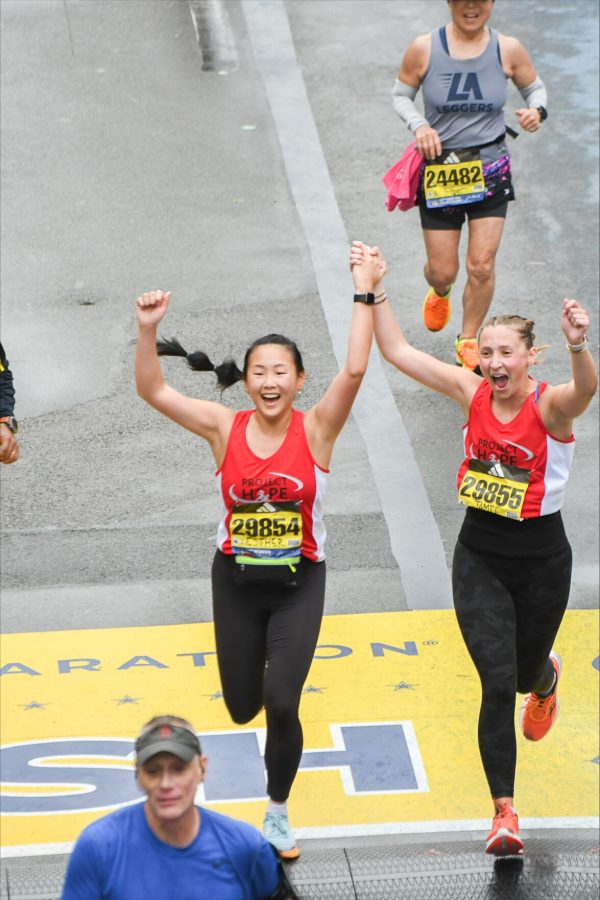 
Jamie Brenner and Esther Ahn from TikTok account JesterJogs cross the Boston Marathon finish line. Photo by Boston Athletic Association.
