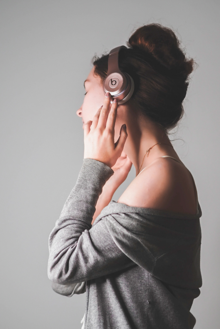 A woman vibes to music. Photo sourced from Unsplash.