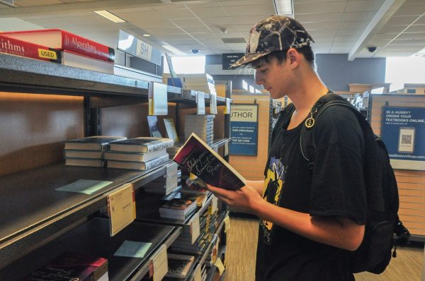 Gavin looks through poetry books in the campus bookstore. Photo by Milanya Gordiyenko / Contributing Photographer.
