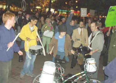 Thomas Barker (far left) a UMB student, beats a protest drum at Copley Square about halfway through the October 4 protest.
 
