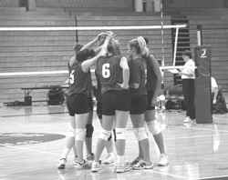 The UMB volleyball team huddle to regroup after dropping the first set in their match against Newbury College.
 