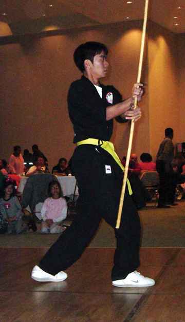 A martial artist demonstrates the use of the bo in a kata, or fighting exercise.
 