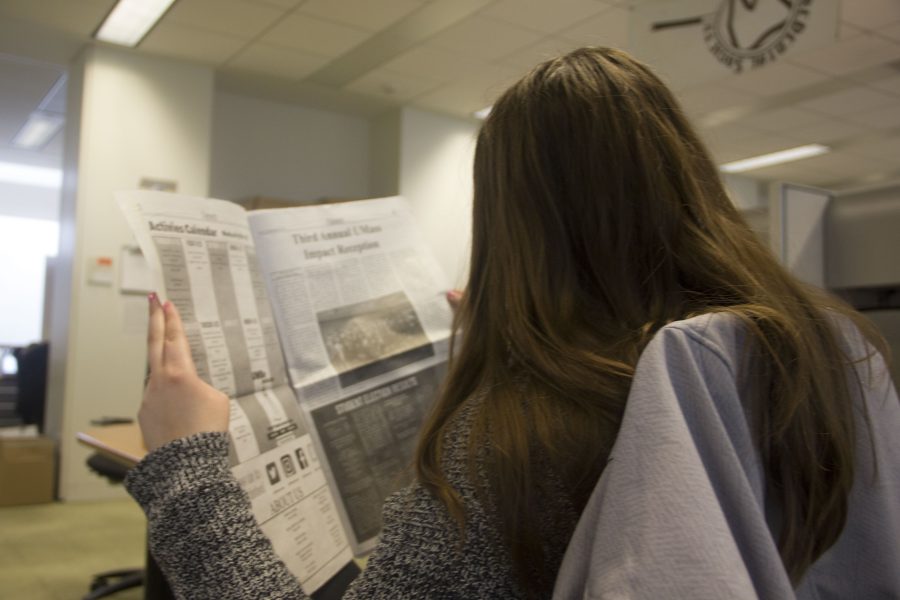 Student, Jennifer Magee, reading the newspaper.