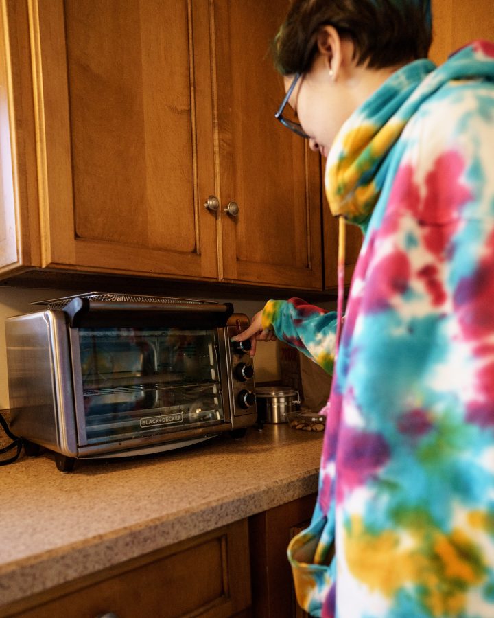 Woman selecting the “air fry” setting on a toaster oven.