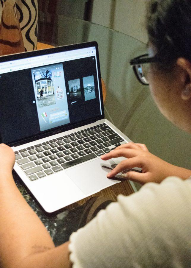 UMass Boston student looks through her Instagram feed on laptop.