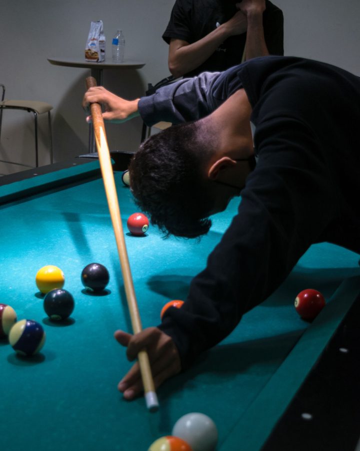 A student hangs his head in defeat during a pool game.