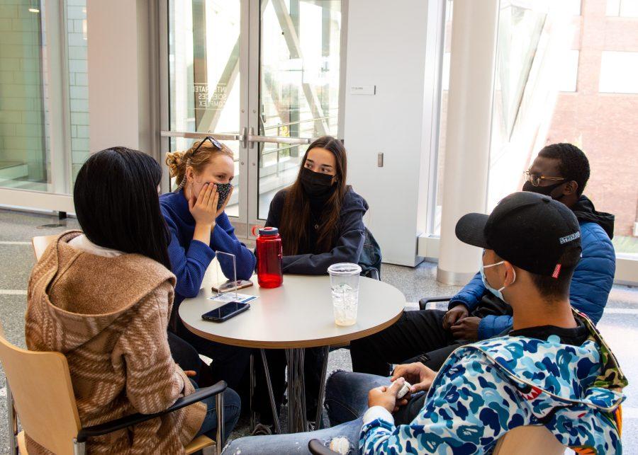 UMass Boston students sit at a table in the Integrated Science Complex.