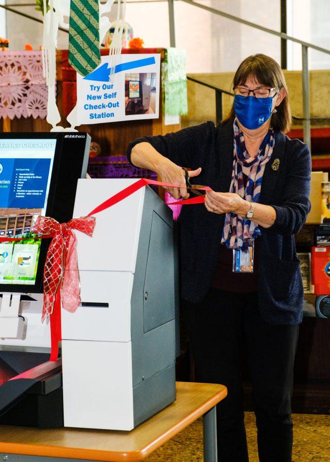 Interim+Dean+of+the+Library+Joanne+Riley+cutting+the+ribbon+off+of+the+newly+installed+self-checkout+station.