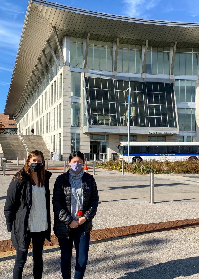 Ashley Luce, Program Coordinator (left), and Tatiana, MAICEI Student (right) stand in front of the UMass Boston Campus Center.