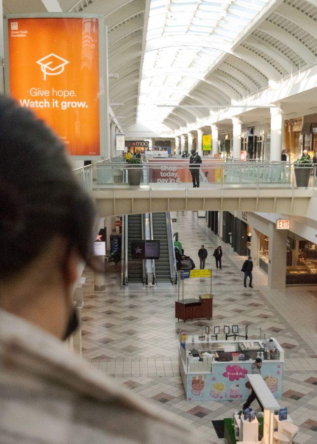 A shopper observes the stores below her at the South Shore Mall in Braintree, MA.
