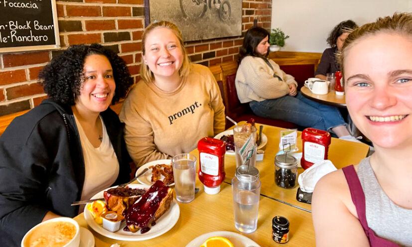 Cristina Miranda, Emily Huckins, and Lucy Camarata (L-R) sit for lunch in Trident Booksellers & Cafe in Boston on March 15, 2022.
