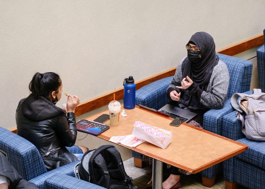 Two UMass Boston students sit in the Campus Center lounge to have a quick bite and socialize.