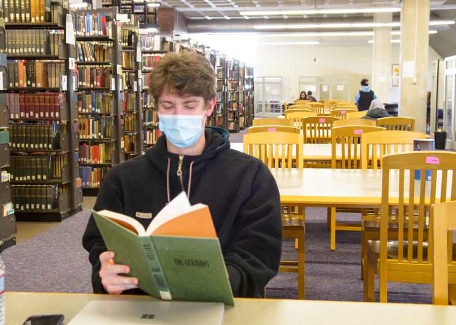 A UMass Boston student relaxes with a book in the Healey Library.