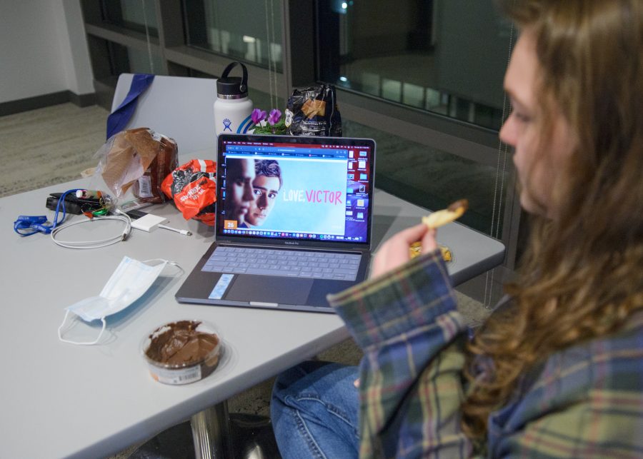 UMass Boston student Jenna enjoys some snacks as she watches Love Victor in the lounge of the East Residence Hall.