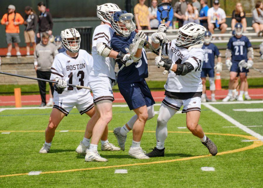 Three UMass Boston players block an advancing Mass. Maritime attacker in their first conference tournament match-up on Thursday, May 5.