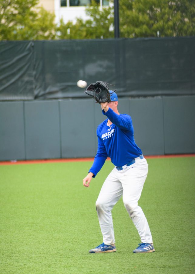 Beacons baseball player catches a baseball during a game.