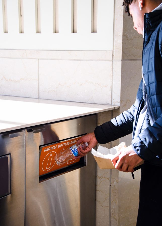 Danny makes sure to properly dispose of his plastic water bottle at the food court in Campus Center.