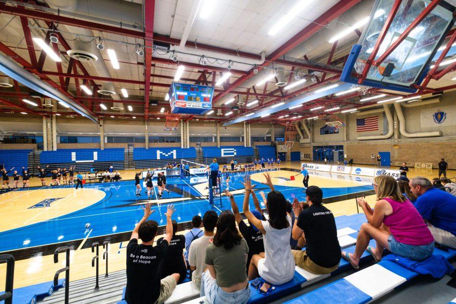 Students cheer at a volleyball game in Clark Athletic Center.