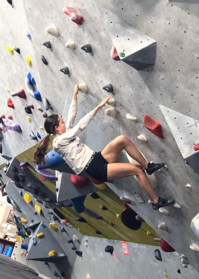 A climbing club member participates in an activity called bouldering—free climbing on a rockwall with foot and hand holds.