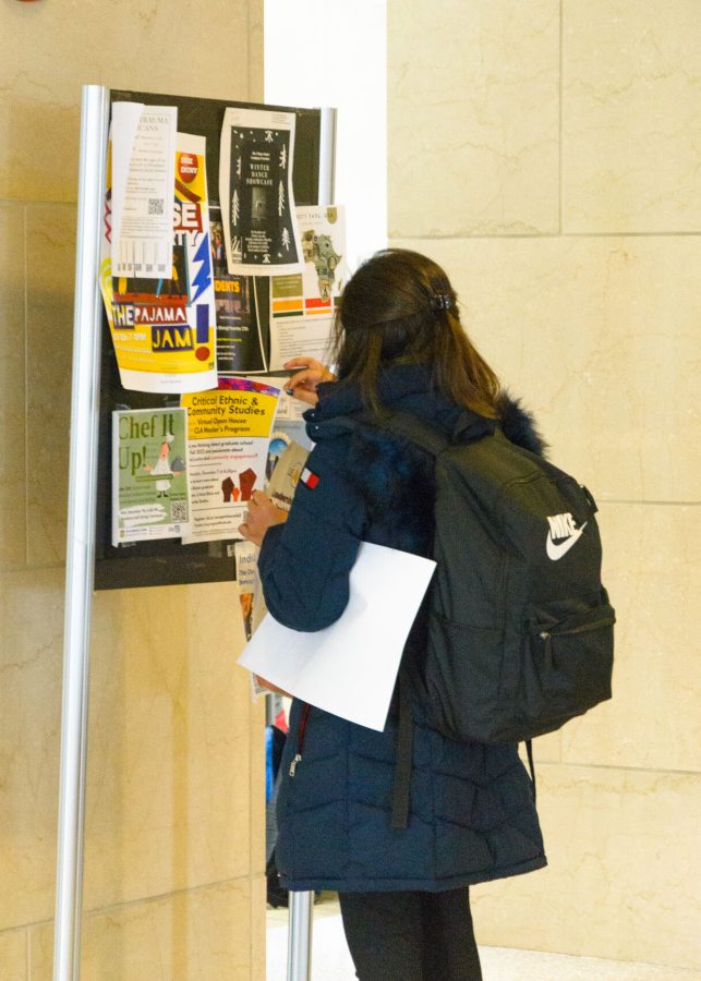 Katherine puts up posters in the Campus Center to spread word about on-campus leadership opportunities.
