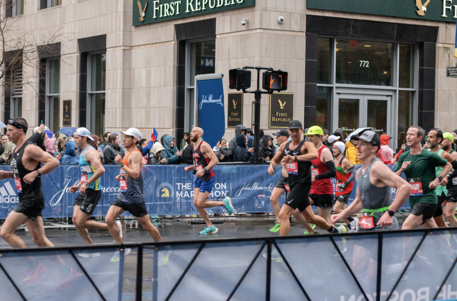 Runners stride to get to the finish line of the Boston Marathon. Photo by Colin Tsuboi (He/Him) / Mass Media Staff.