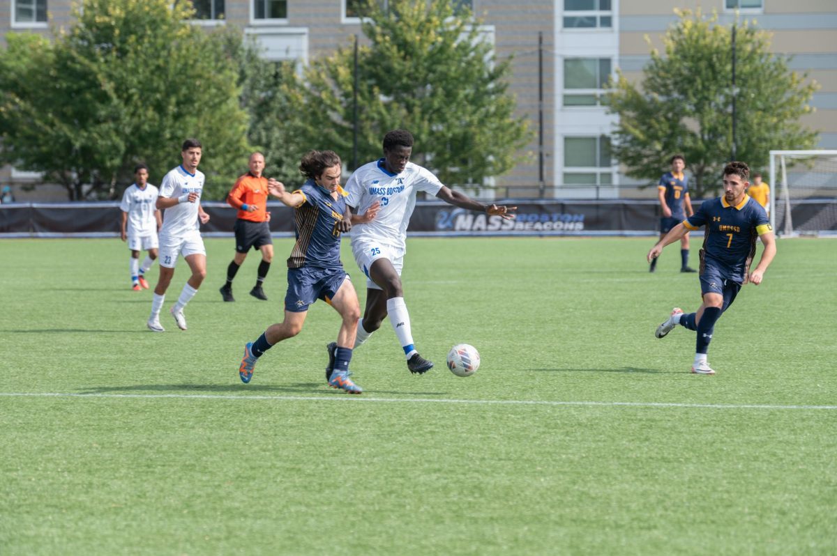 Men’s soccer player Marron Achaempong fights a UMass Dartmouth player for the ball. Photo by Olivia Reid / Photography Editor.