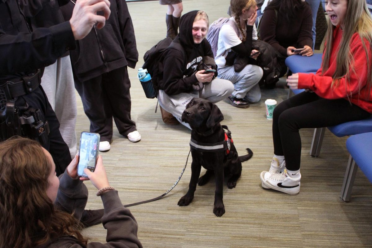 Students circle around K-9 Beacon for photos before his swearing-in ceremony in the Campus Center. Photo by Georgia Berry / Production Editor.