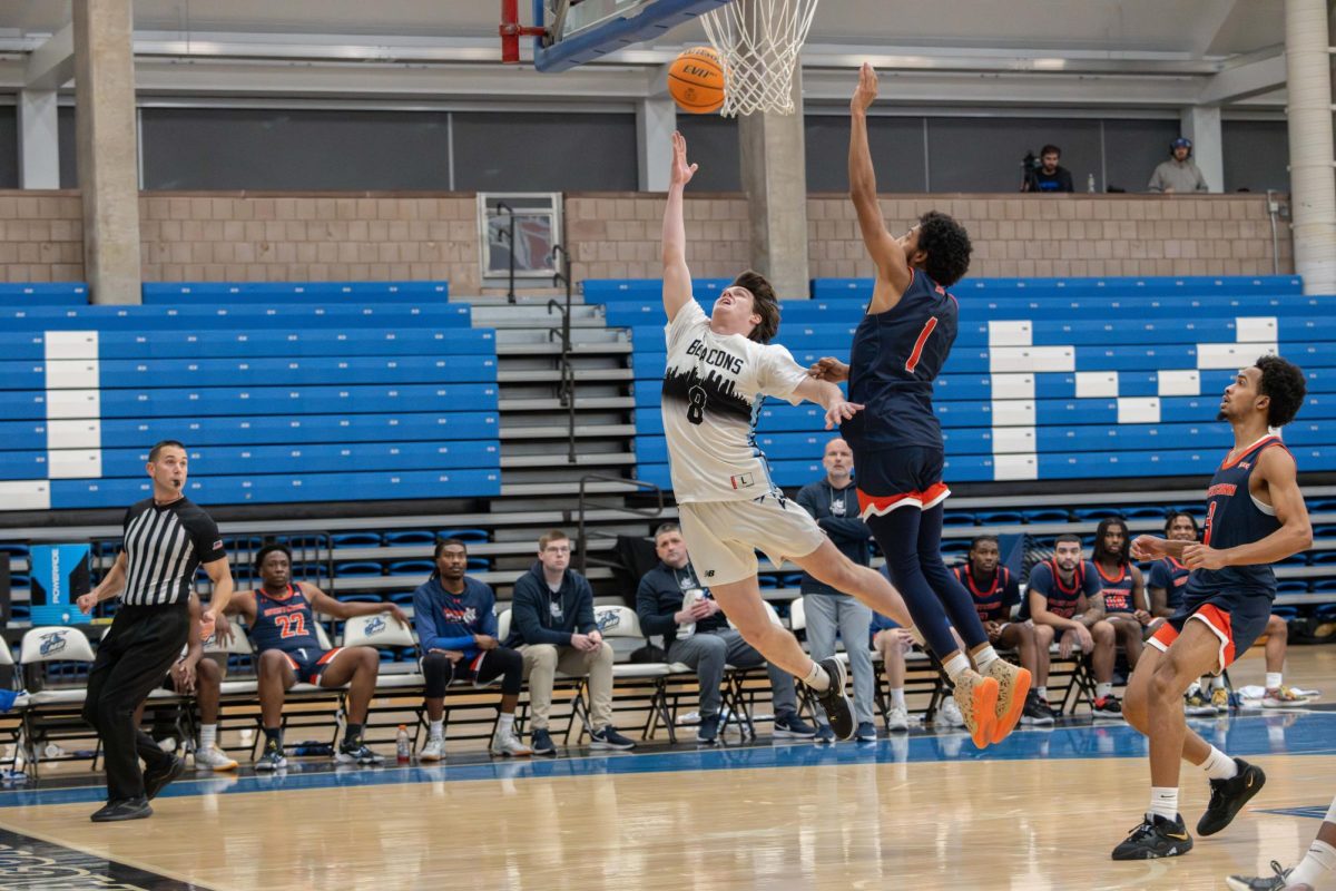 Men’s basketball player Carson Meczywor goes for a layup during a home game. Photo by Dong Woo Im / Mass Media Staff.