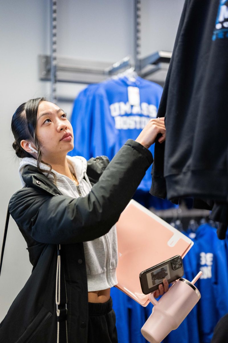 A student shops in the UMass Boston Bookstore for merchandise. Photo by Dong Woo Im / Mass Media Staff.