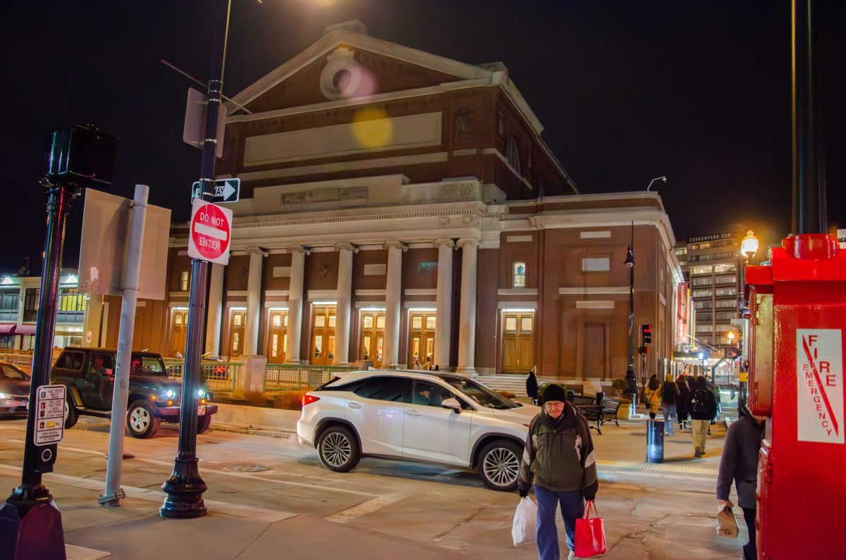 People pass by the Boston Symphony Orchestra at night. Photo by Saichand Chowdary / Mass Media Staff.
