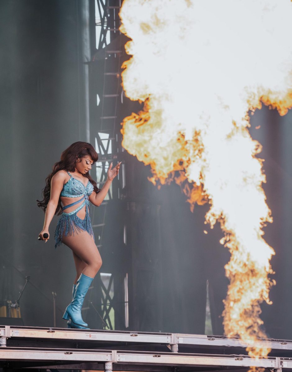 Megan Thee Stallion walking down the stairs as fire goes off on the stage. Photo by Olivia Reid/ Photography Editor. 