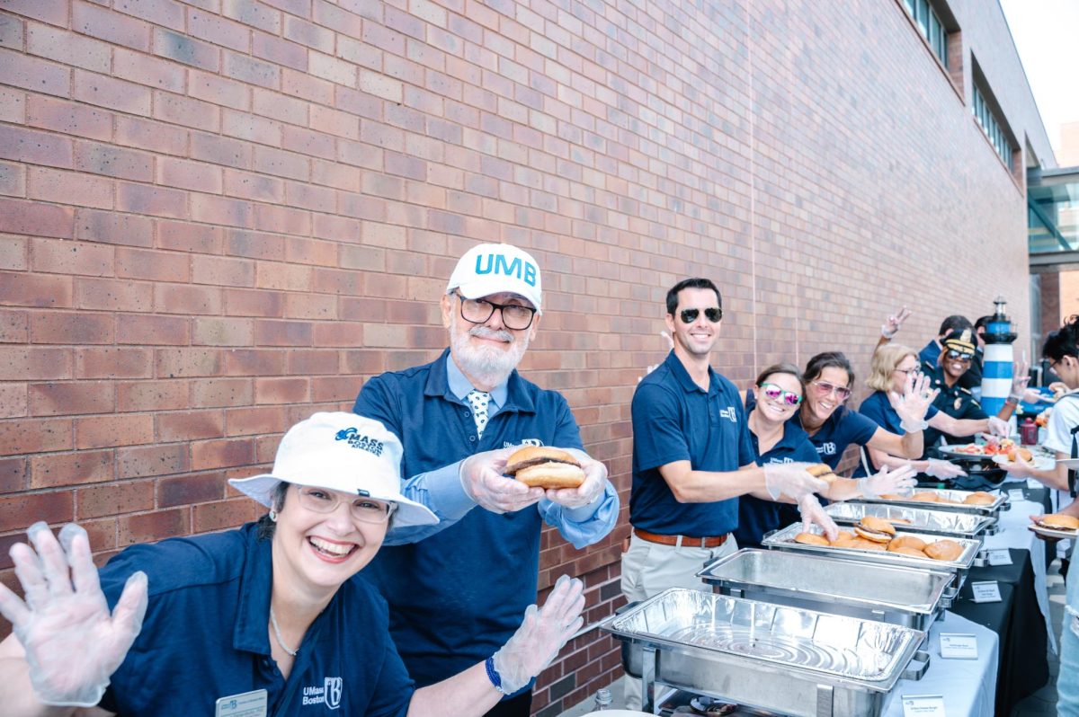 Chancellor Marcelo Suárez-Orozco holds a hamburger at the Chancellor's Barbecue Sept. 12, along with other members of administration. 