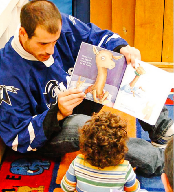 Jimmy Ennis reads to the children of UMass Boston's Early Learning Center. Photo via The Mass Media courtesy of Beacon Athletics. 