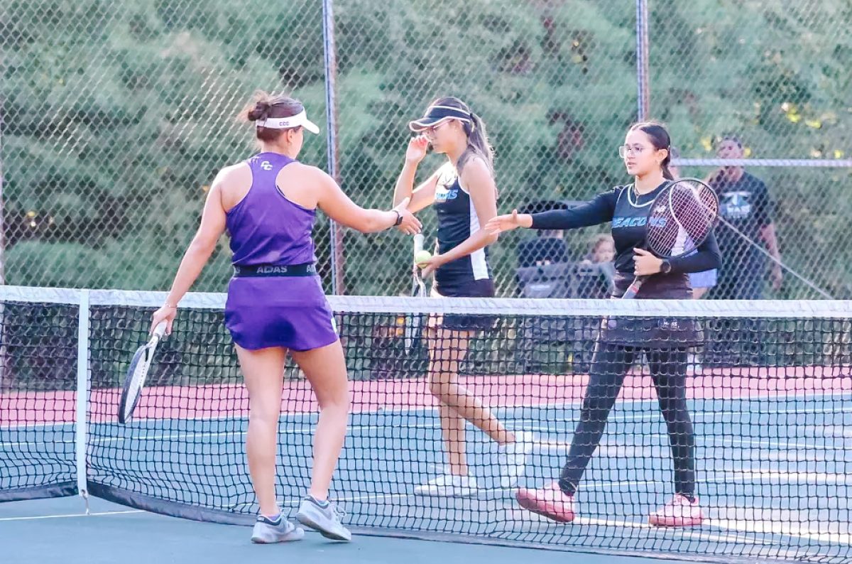 Women's tennis players shake hands before their match against Albertus Magnus College on Sept. 13. Photo from Beacon Athletics. 