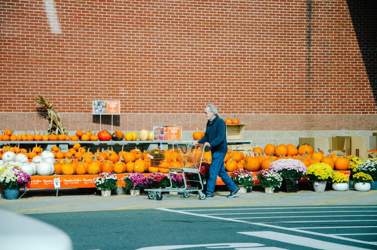 A local shopper walks past pumpkins at the grocery store as fall begins.