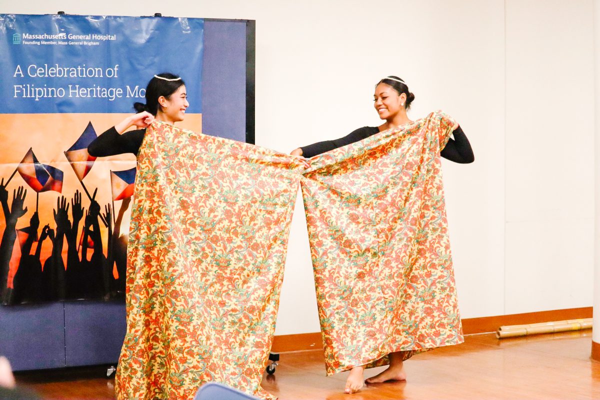 "Hoy Pinoy!'s Clare Alanguilan (left) and Fasha Banson (right) performing the Kappa Malong Malong dance at Mass General Hospital". Photo taken by Naomi Layon (they/them)