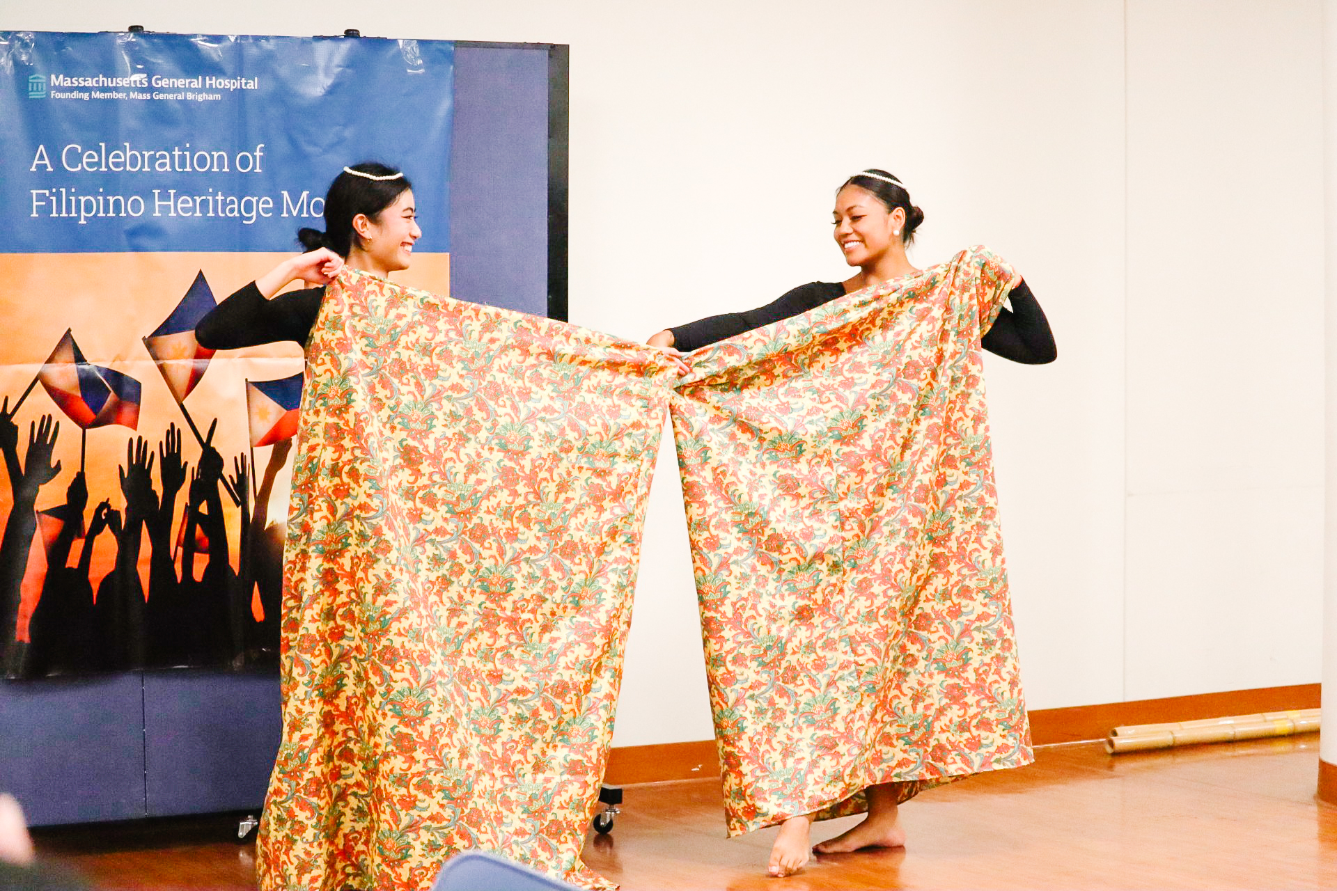 "Hoy Pinoy!'s Clare Alanguilan (left) and Fasha Banson (right) performing the Kappa Malong Malong dance at Mass General Hospital". Photo taken by Naomi Layon (they/them)