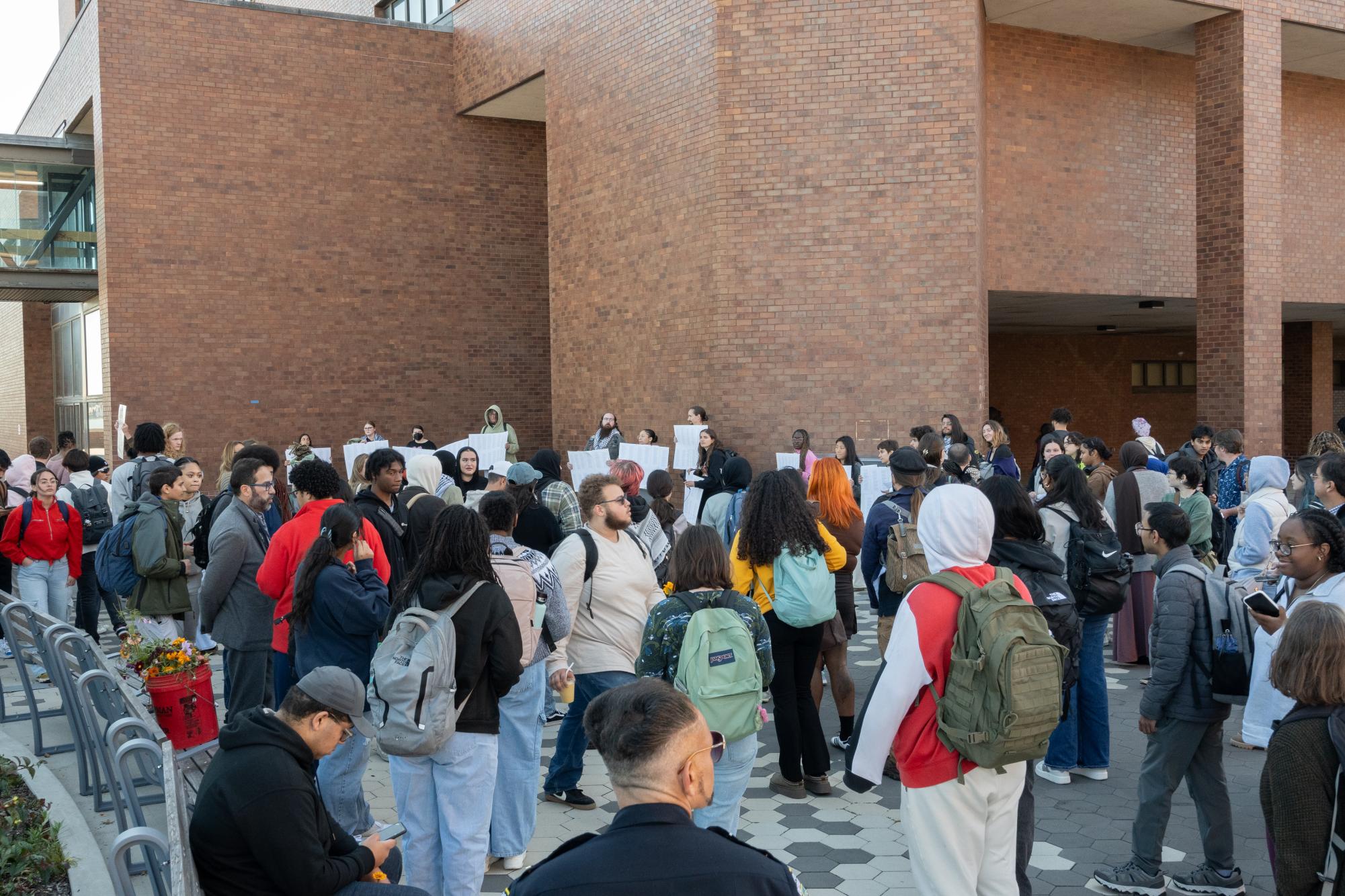 Attendees and organizers stand around the Oct. 8 vigil, which included pictures of Marcellus Williams and Aysenur Ezgi Eygi. 