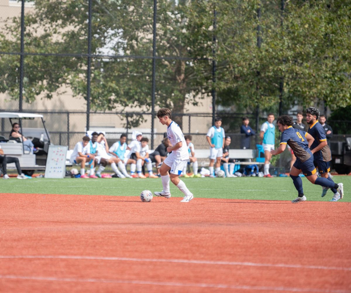 Men’s soccer player dribbles down field in the final game of the season.