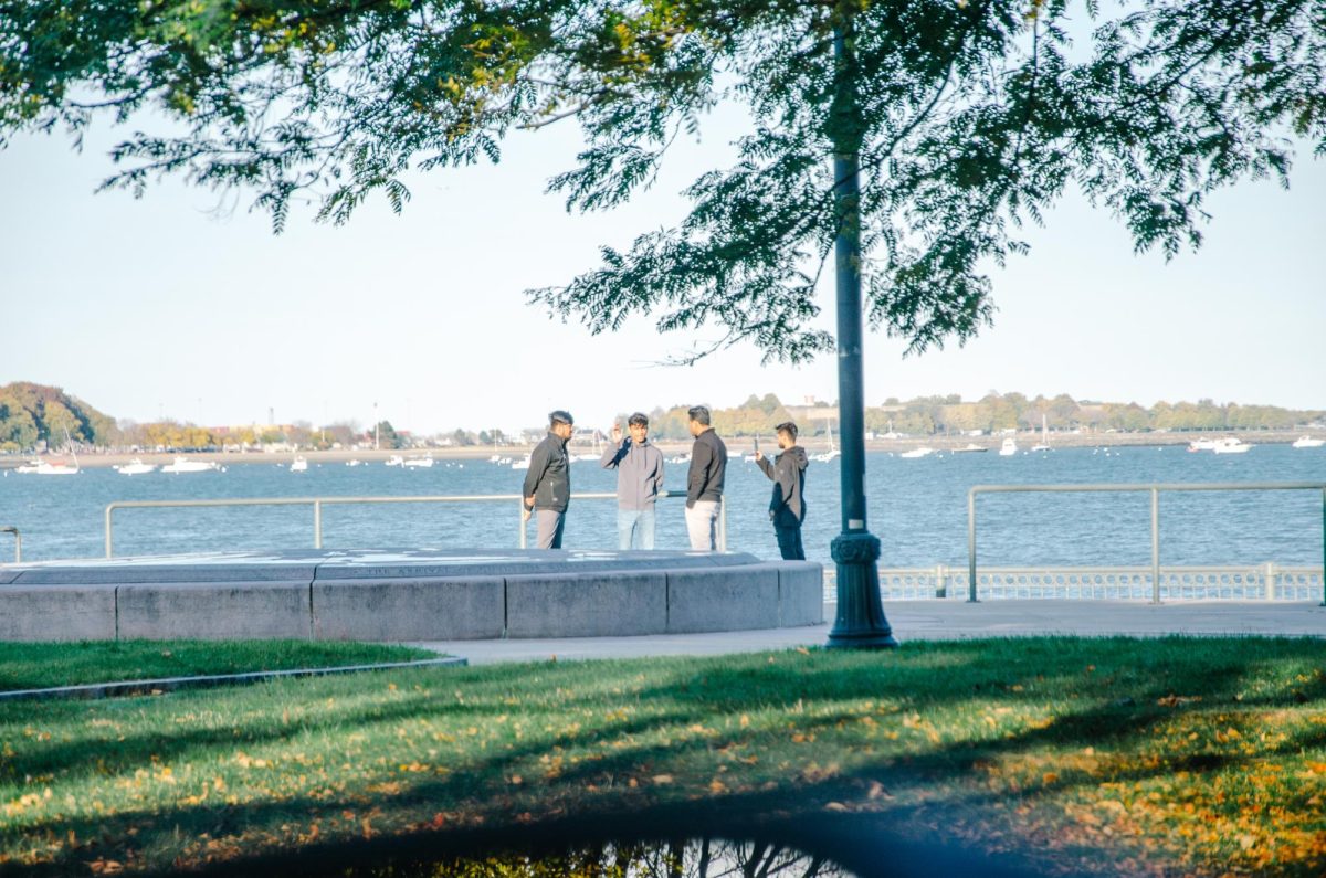 Students have a conversation by the harbor walk.