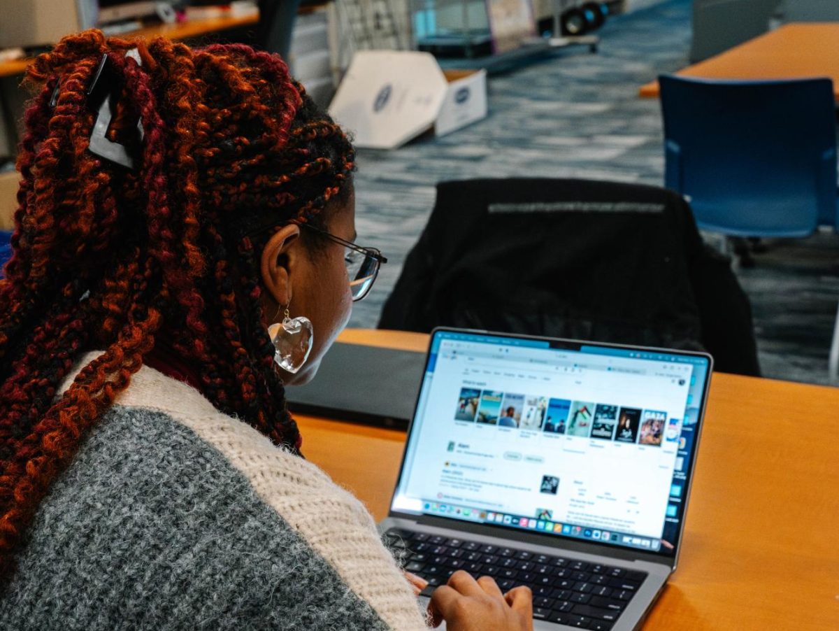 A student browses through Palestinian films, many of which are free through the Healey Library.