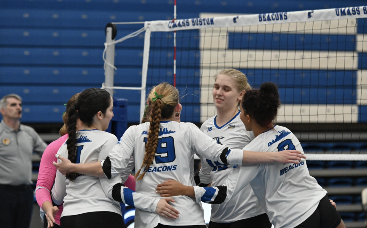 Women's volleyball huddles up during a winning game.