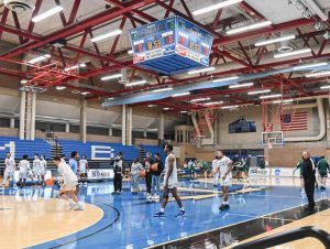 The men's basketball team gathers during their season opener.