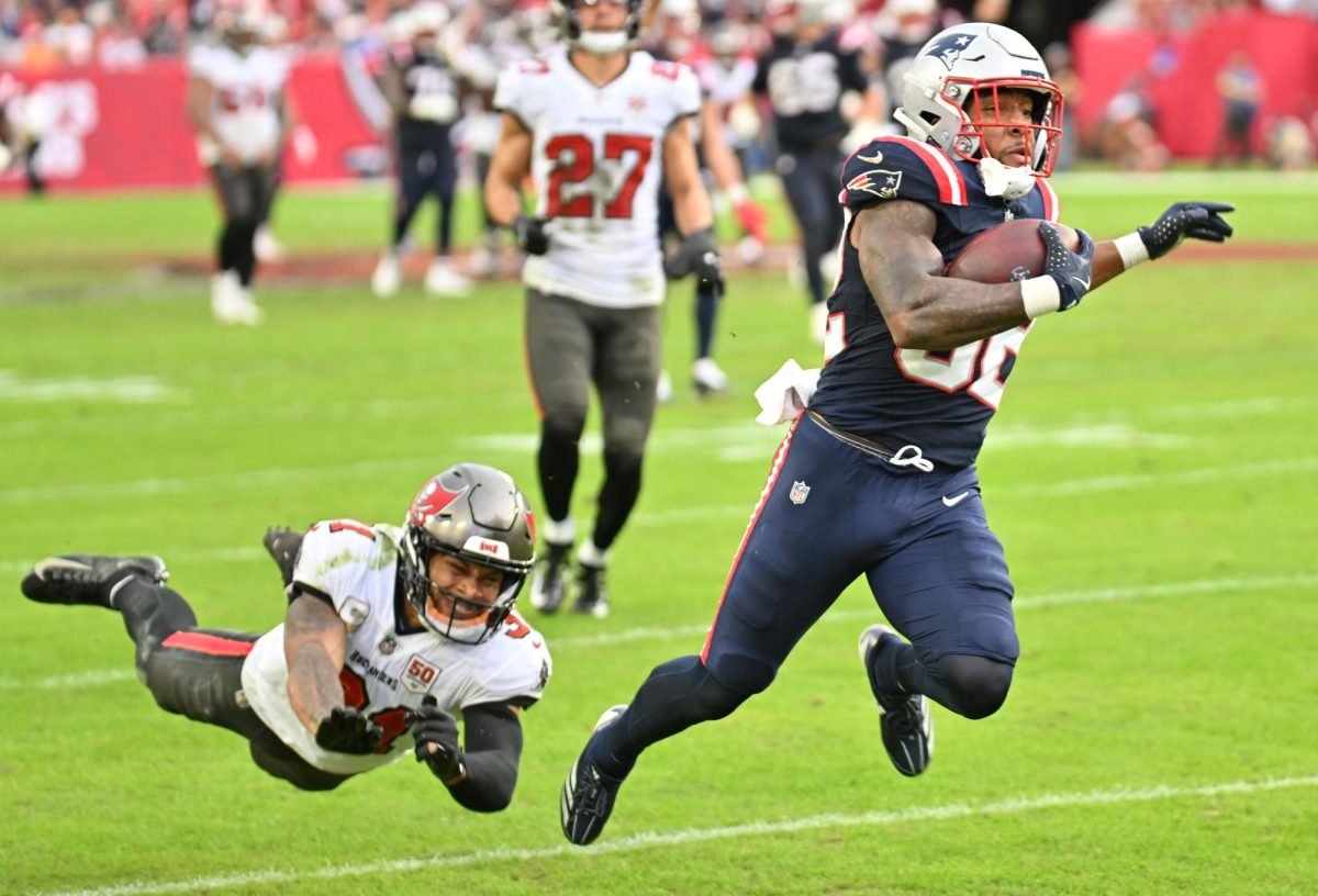 New England Patriots running back Treveyon Henderson (32) runs for a touchdown past Tampa Bay Buccaneers cornerback Josh Hayes (32) during the third quarter at Raymond James Stadium. Mandatory Credit: Jonathan Dyer via Imagn Images